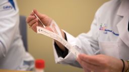 A pathologist holds a nasal swab from a COVID-19 test kit at the Core Lab in Northwell Health's Center for Advanced Medicine in Lake Success, New York, U.S., on Wednesday, March 4, 2020. On Monday, Northwell Health Labs announced it expects to begin testing for the coronavirus within a week, now that the US Food & Drug Administration (FDA) has given the green light for outside labs to conduct the COVID-19 tests once appropriately validated.