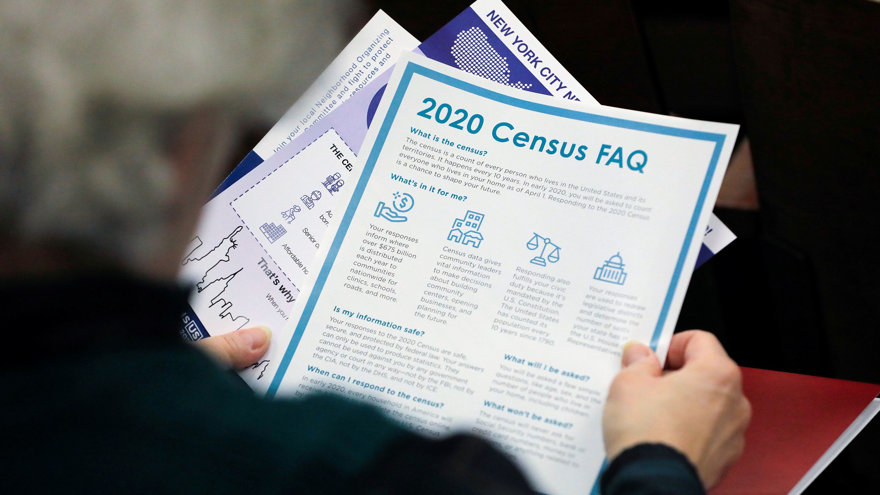 In this February 22, 2020, file photo, a person holds census information at a Census Town Hall at the Louis Armstrong Middle School in Queens, New York.