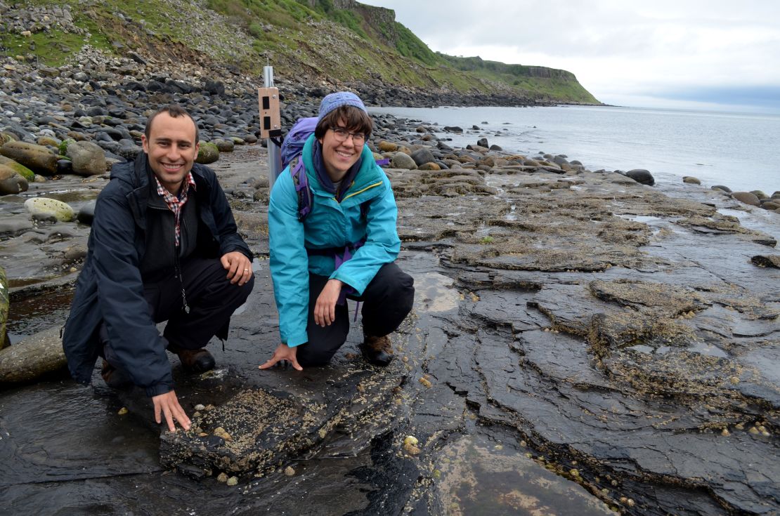 Steve Brusatte and Paige dePolo pose with fossil dinosaur tracks on the Isle of Skye.