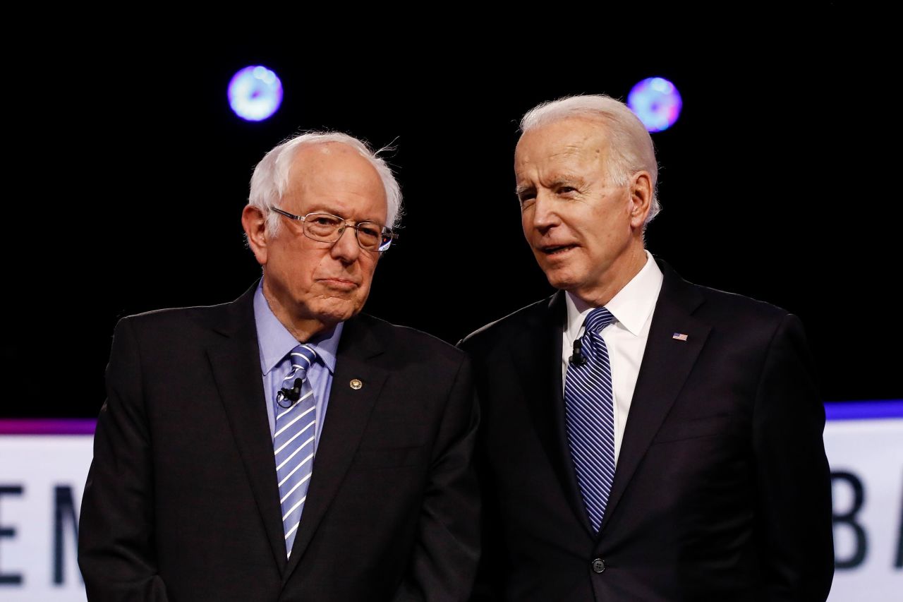 Sanders and former Vice President Joe Biden talk before a Democratic debate in Charleston, South Carolina, in February 2020.