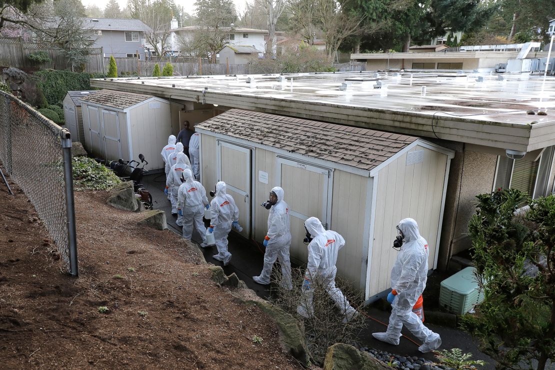 A disaster recovery team wearing protective suits and respirators enters Life Care Center in Kirkland, Washington, to disinfect the facility on Wednesday, March 11, 2020.