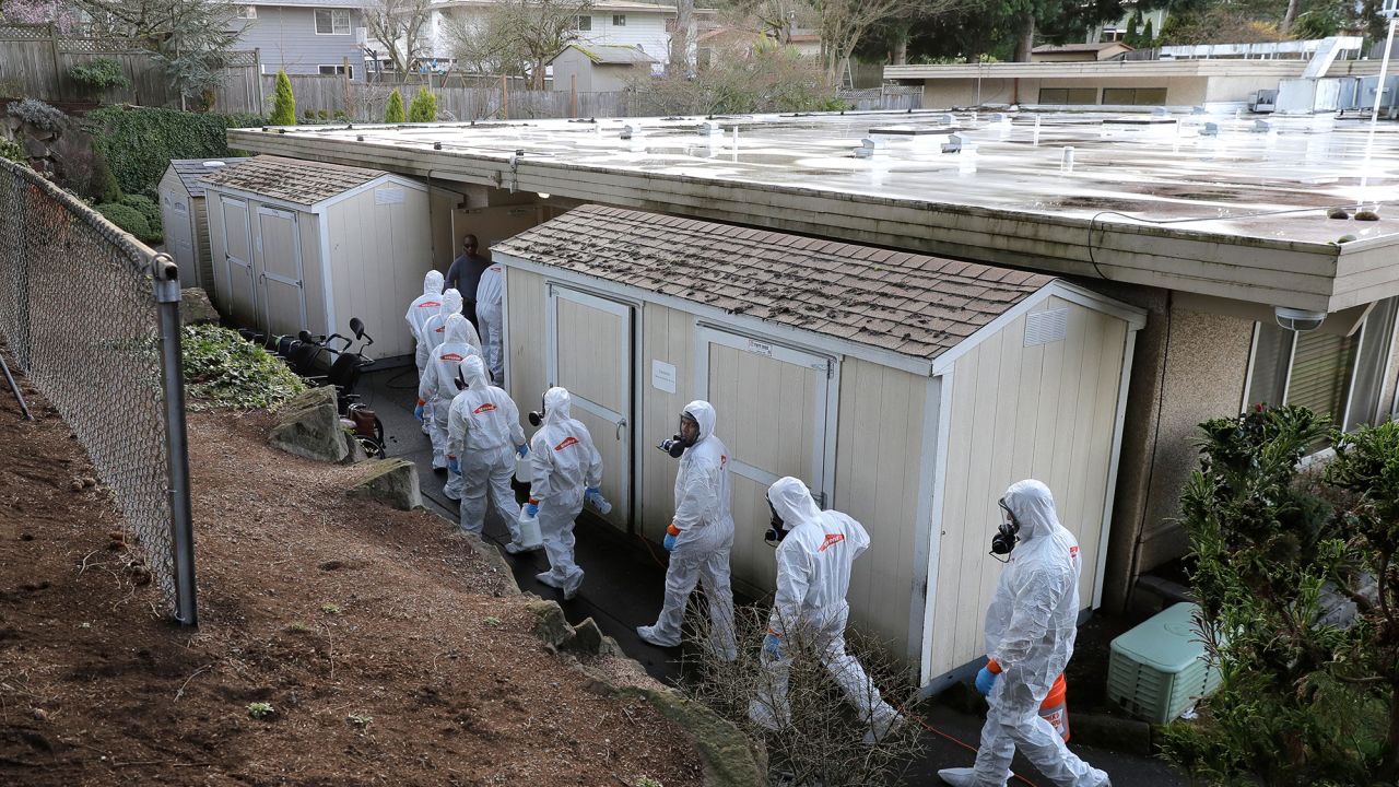 A disaster recovery team wearing protective suits and respirators enters Life Care Center in Kirkland, Washington, to disinfect the facility on Wednesday, March 11, 2020.