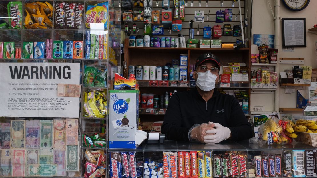 A worker wears a protective mask and gloves Wednesday at a deli in New Rochelle.