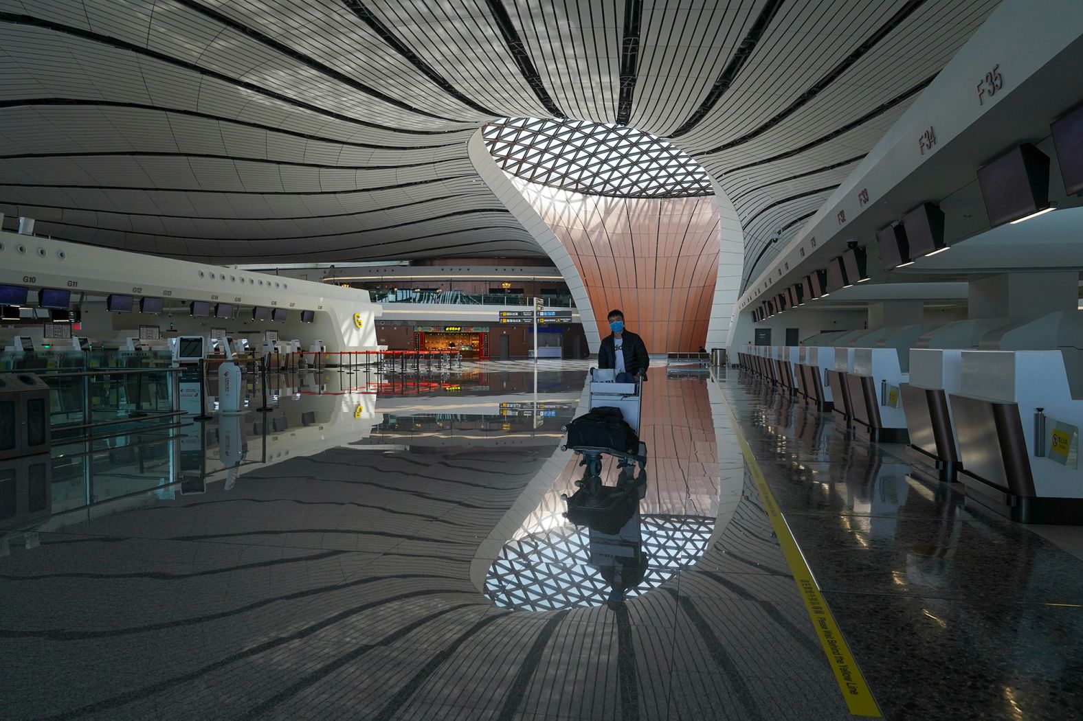 A passenger walks in the empty check-in area of the Beijing Daxing International Airport on March 3.