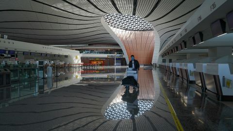 A passenger walks in the empty check-in area of the Beijing Daxing International Airport on March 3.