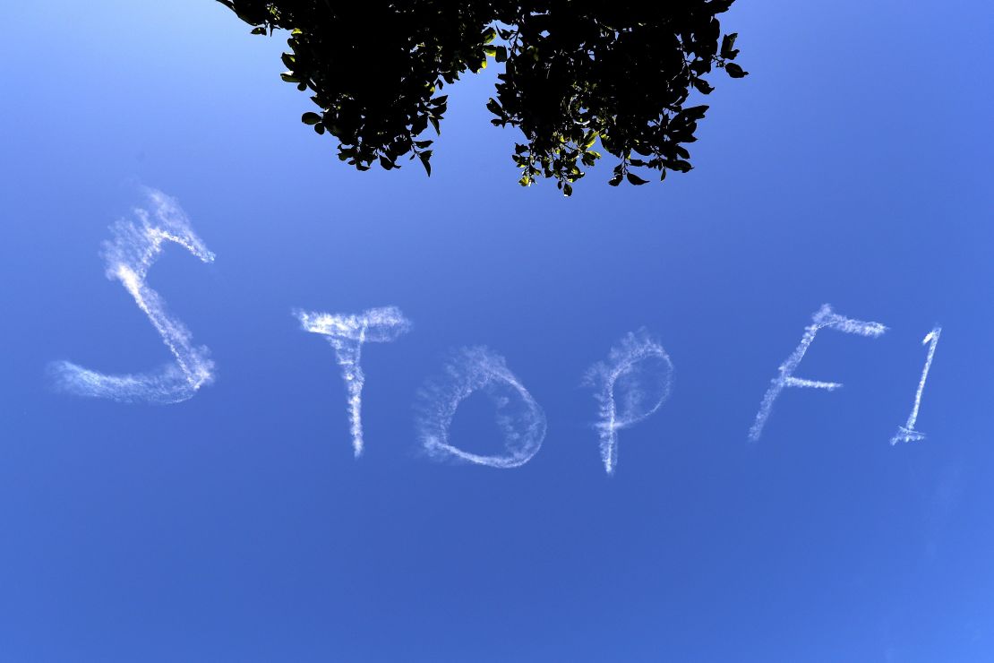 The words "Stop F1" are seen over the Sydney sky.