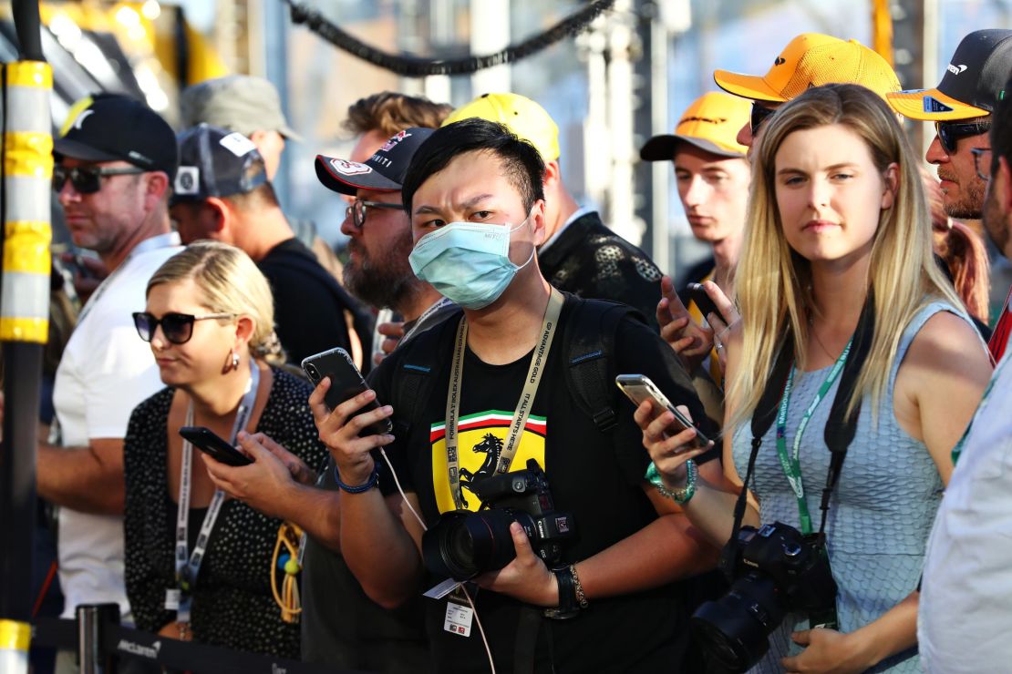 A fan wears a protective mask while standing in the pitlane during previews ahead of the F1 Grand Prix in Australia.