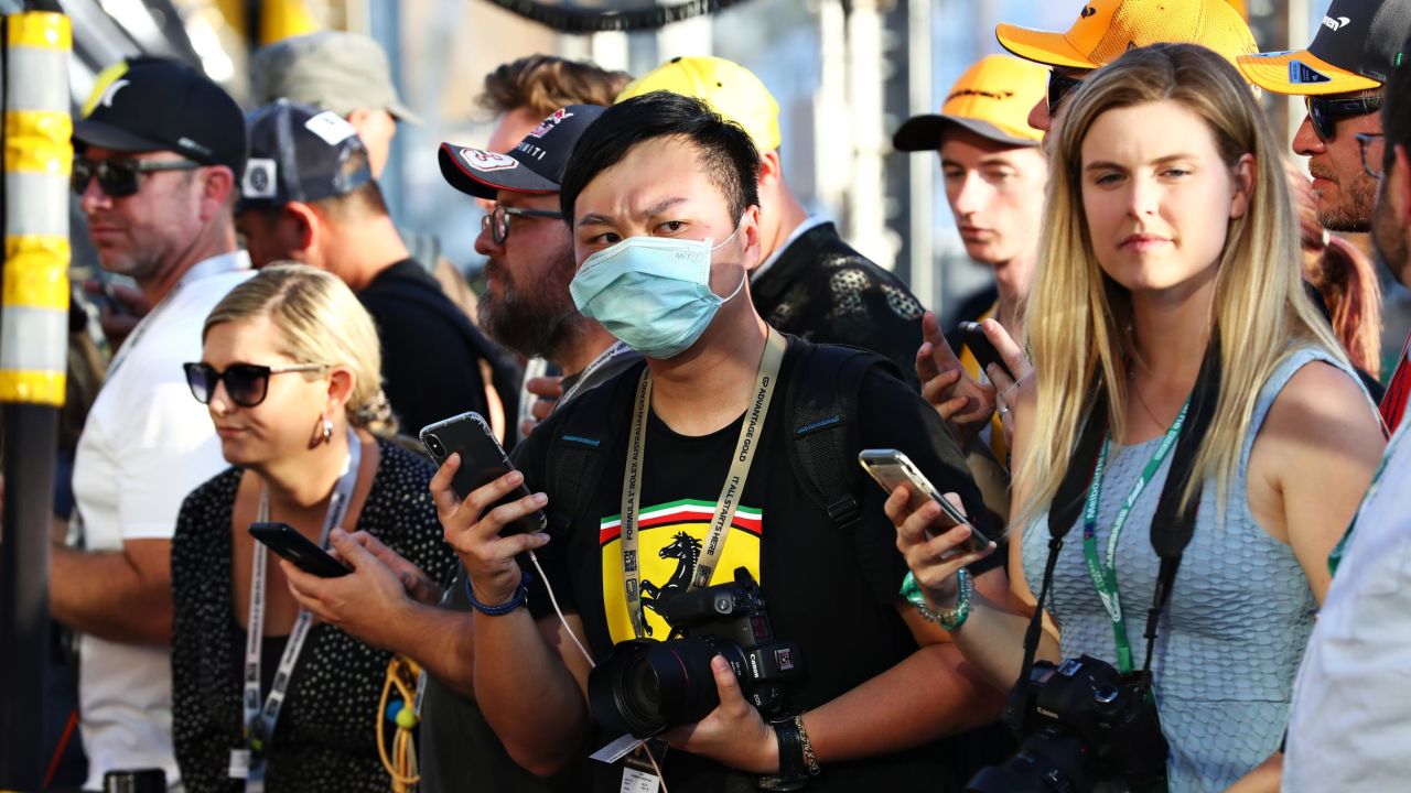 A fan wears a protective mask while standing in the pitlane during previews ahead of the F1 Grand Prix in Australia.