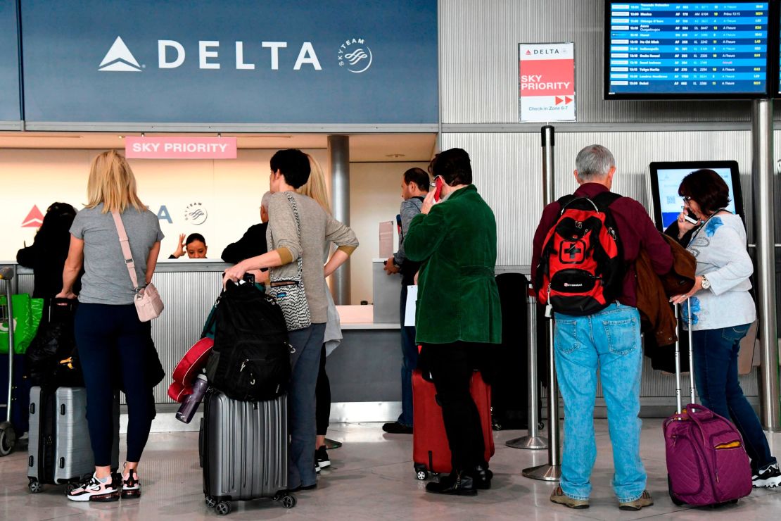 Travellers line up at a Delta Airlines desk at Paris-Charles-de-Gaulle airport, following the announcement of the US Europe travel ban.