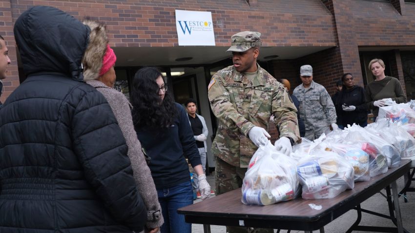 Members of the New York National Guard help to organize and distribute food to families on free or reduced school lunch programs in New Rochelle, N.Y., Thursday, March 12, 2020. State officials have set up a "containment area" in the New York City suburb, where schools and houses of worship are closed within a 1-mile radius of a point near a synagogue where an infected person with coronavirus had attended events. State officials stress it is not a lockdown. The vast majority of people recover from the new coronavirus. According to the World Health Organization, most people recover in about two to six weeks, depending on the severity of the illness. (AP Photo/Seth Wenig)