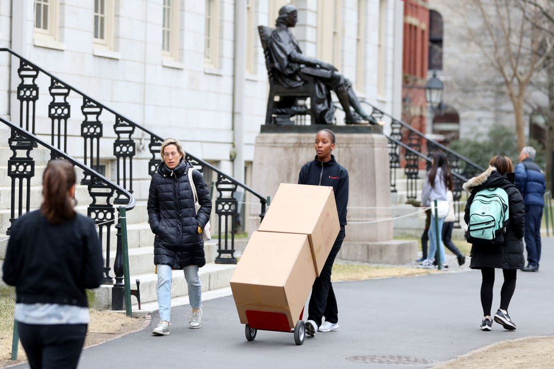 Sophomore Sadia Demby moves her belongings through Harvard Yard on March 12.