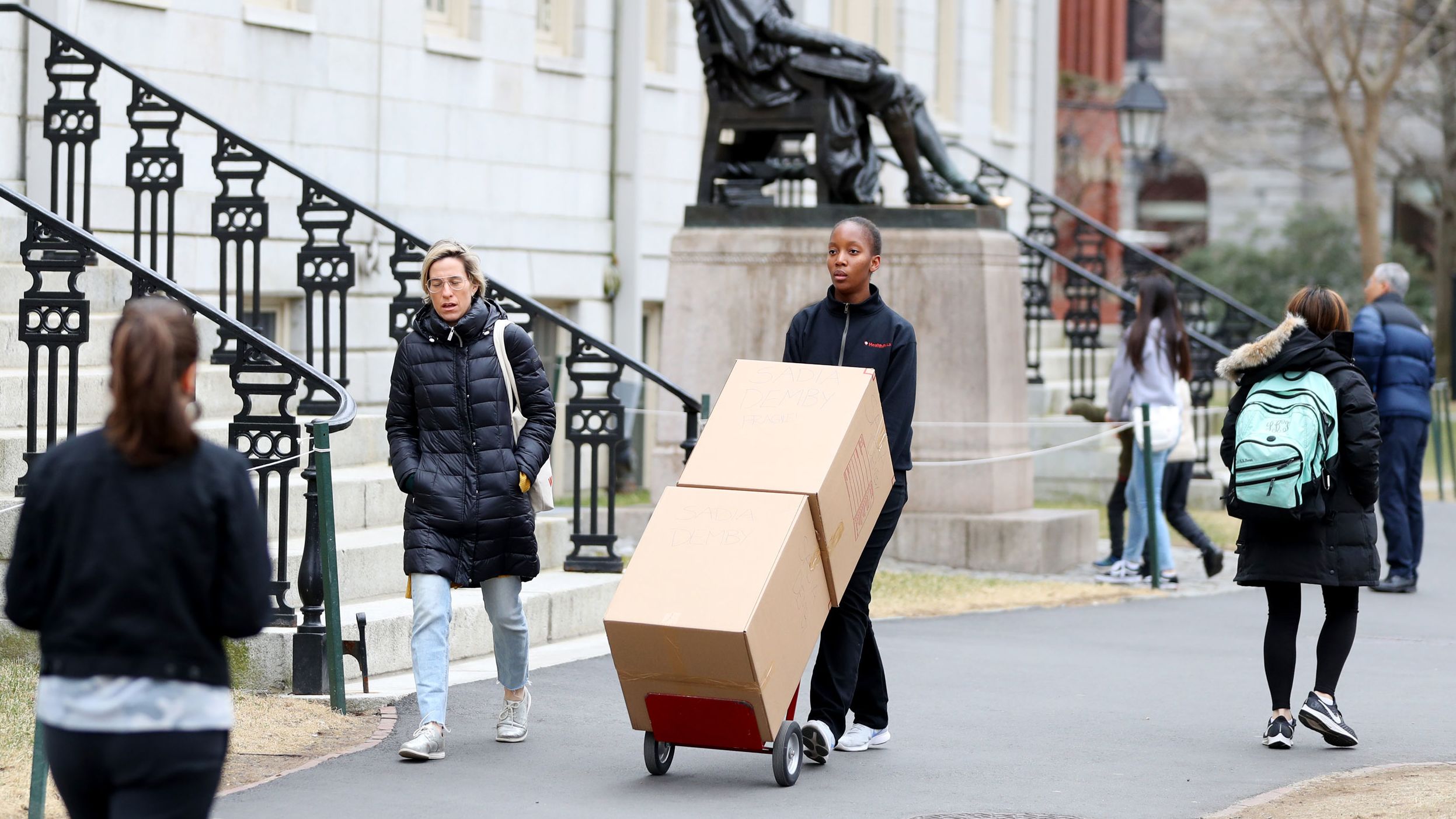 Sophomore Sadia Demby moves her belongings through Harvard Yard on March 12.