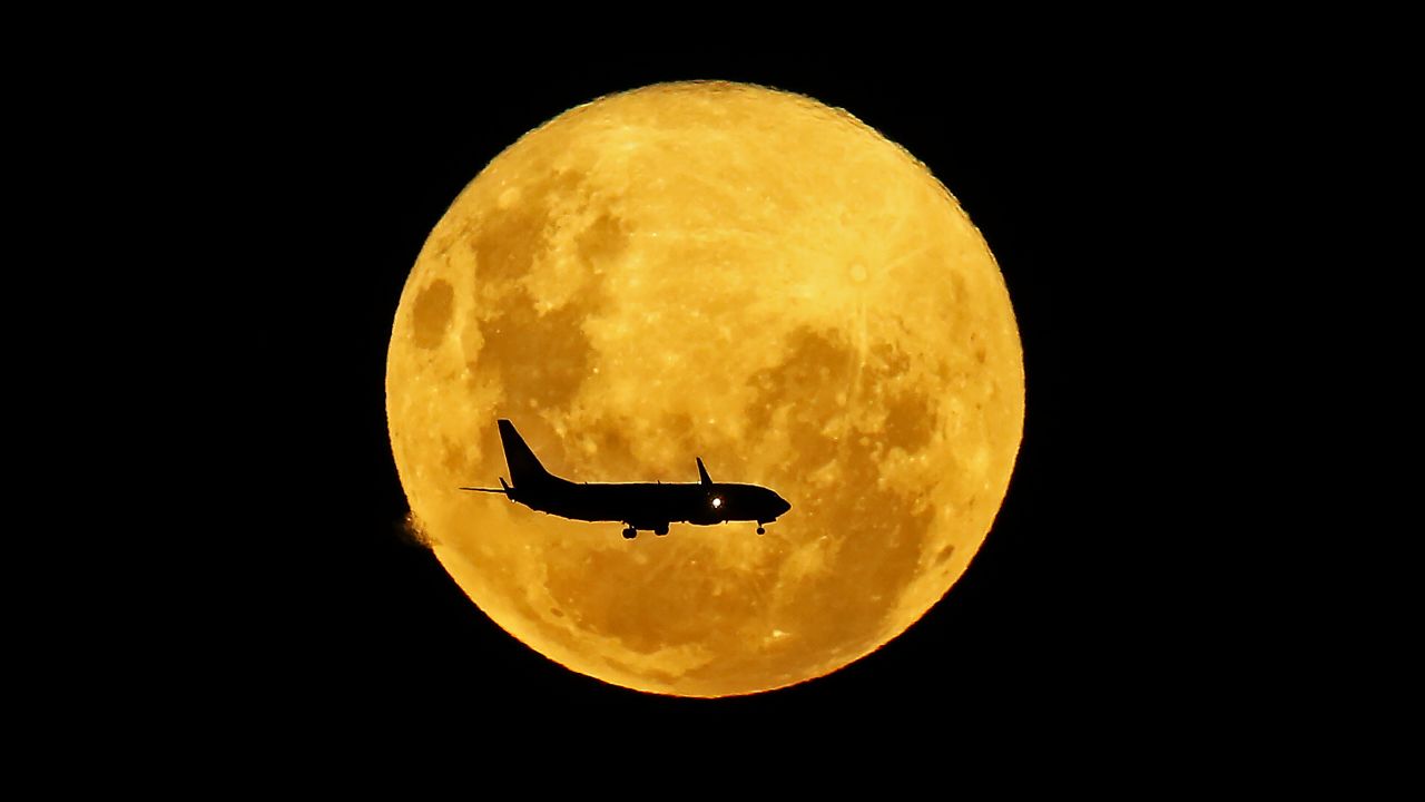This image, taken in Brazil, shows a plane passing in front of the supermoon in March 2020. 