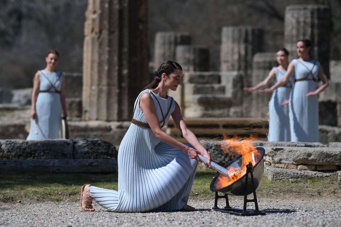A woman dressed as a priestess lights the Olympic flame during a ceremony in Olympia, Greece, on Thursday, March 12. This year's Summer Games are scheduled to begin in Tokyo in late July.