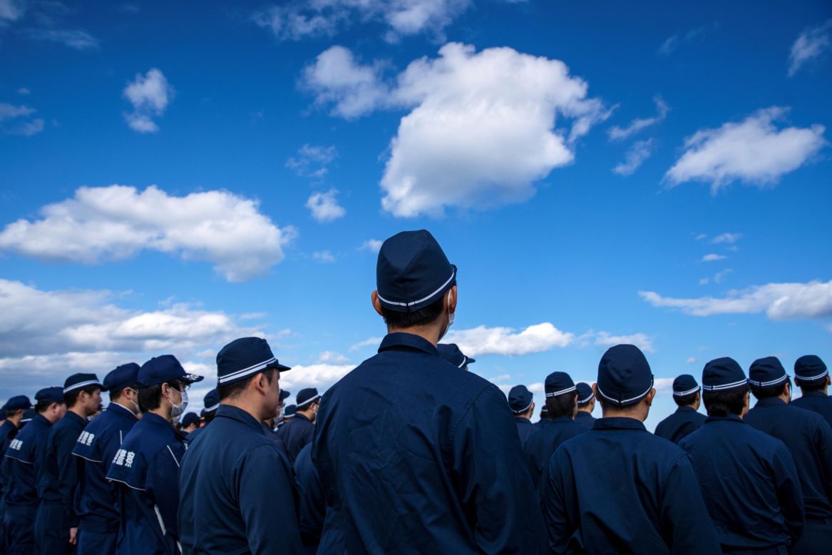Police officers in Namie, Japan, observe a moment of silence on the nine-year anniversary of the earthquake and tsunami that devastated the country on March 11, 2011.