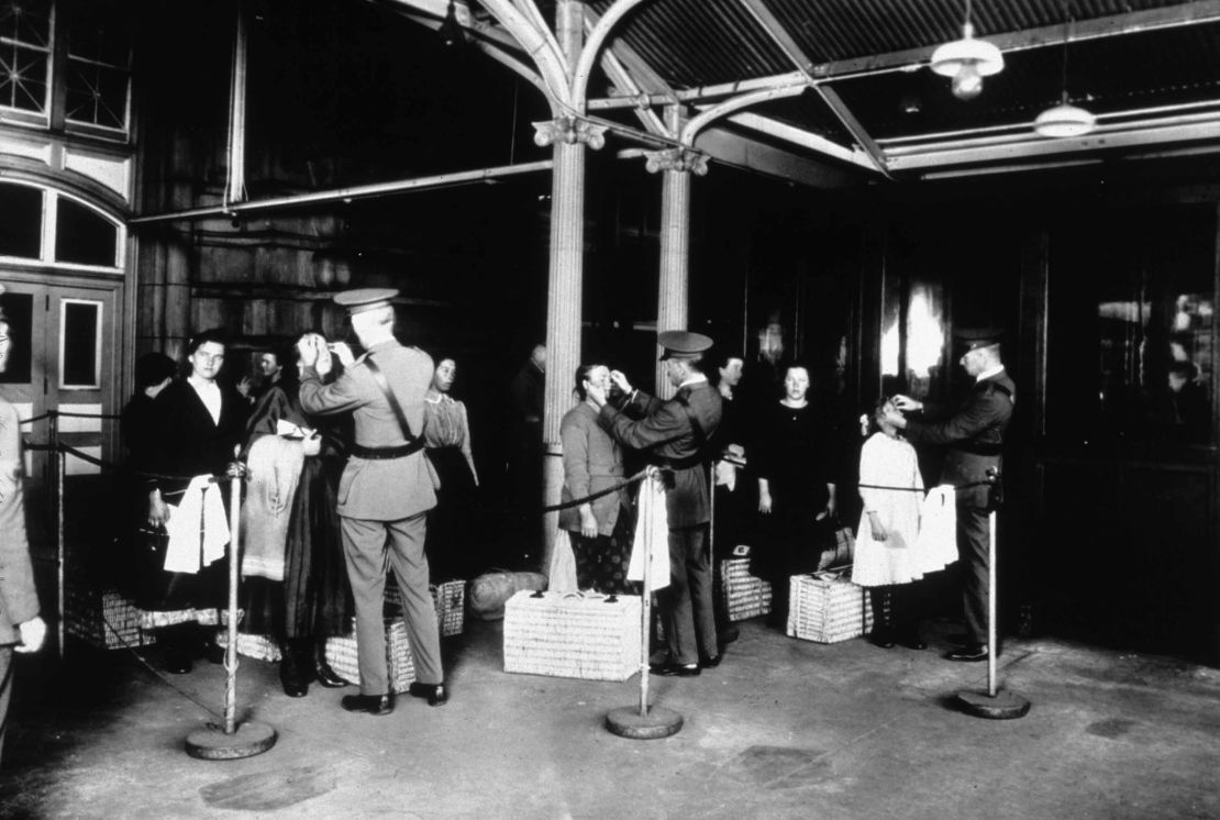 This photo from around 1900 shows new immigrants being inspected at Ellis Island for signs of disease as they arrive in the United States.