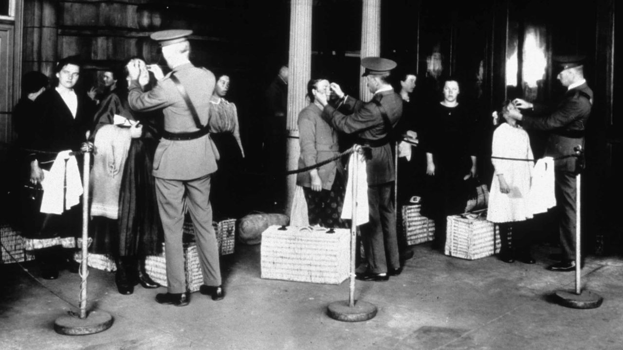 This photo from around 1900 shows new immigrants being inspected at Ellis Island for signs of disease as they arrive in the United States.