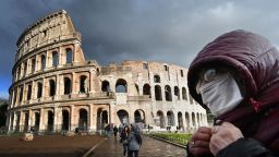 TOPSHOT - A man wearing a protective mask passes by the Coliseum in Rome on March 7, 2020 amid fear of Covid-19 epidemic. - Italy on March 6, 2020 reported 49 more deaths from the new coronavirus, the highest single-day toll to date, bringing the total number of fatalities over the past two weeks to 197. (Photo by Alberto PIZZOLI / AFP) (Photo by ALBERTO PIZZOLI/AFP via Getty Images)