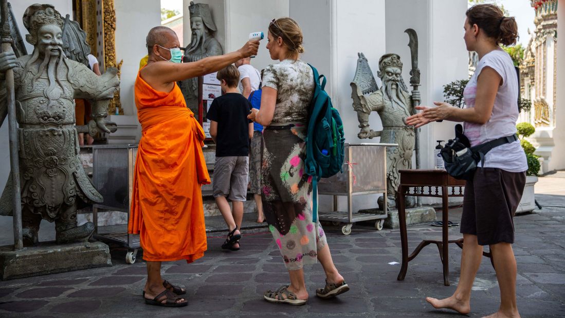 Body temperatures are scanned as people enter the Buddhist temple Wat Pho in Bangkok, Thailand, on March 13.
