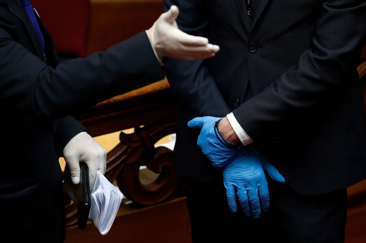 Employees of the Greek Parliament wear plastic gloves ahead of the swearing-in ceremony for Greek President Katerina Sakellaropoulou.