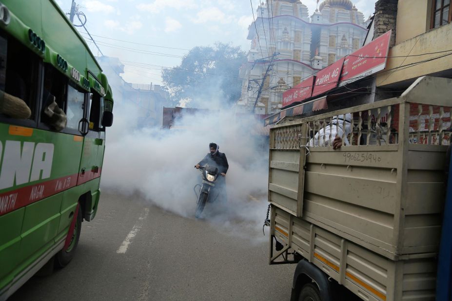 A motorcyclist drives through disinfectant sprayed in Jammu, India, on March 13.