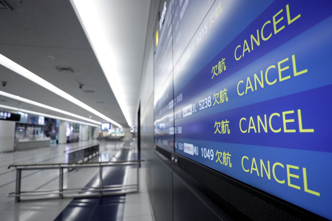 A flight arrival information board displays cancelled flights at an airport in Japan.