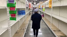 A shopper walks past empty shelves normally stocked with soaps, sanitizers, paper towels, and toilet paper at a Smart & Final grocery store, March 7, 2020 in Glendale, California. - Fears of coronavirus or COVID-19, the disease that has sickened more than 100,000 people worldwide and has killed more than 3,400, has led nervous residents to frantically stock up on canned food as well as cleaning and hygiene products. California prepared to disembark passengers from a virus-hit cruise ship as officials played down any risk to local communities. (Photo by Robyn Beck/AFP/Getty Images)