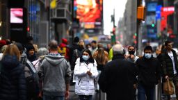 Tourists with protective face masks walk through Times Square on March 13, 2020 in New York City. - The World Health Organization said Friday it was not yet possible to say when the COVID-19 pandemic, which has killed more than 5,000 people worldwide, will peak. "It's impossible for us to say when this will peak globally," Maria Van Kerkhove, who heads the WHO's emerging diseases unit, told a virtual press conference, adding that "we hope that it is sooner rather than later". (Photo by Johannes Eisele/AFP/Getty Images)
