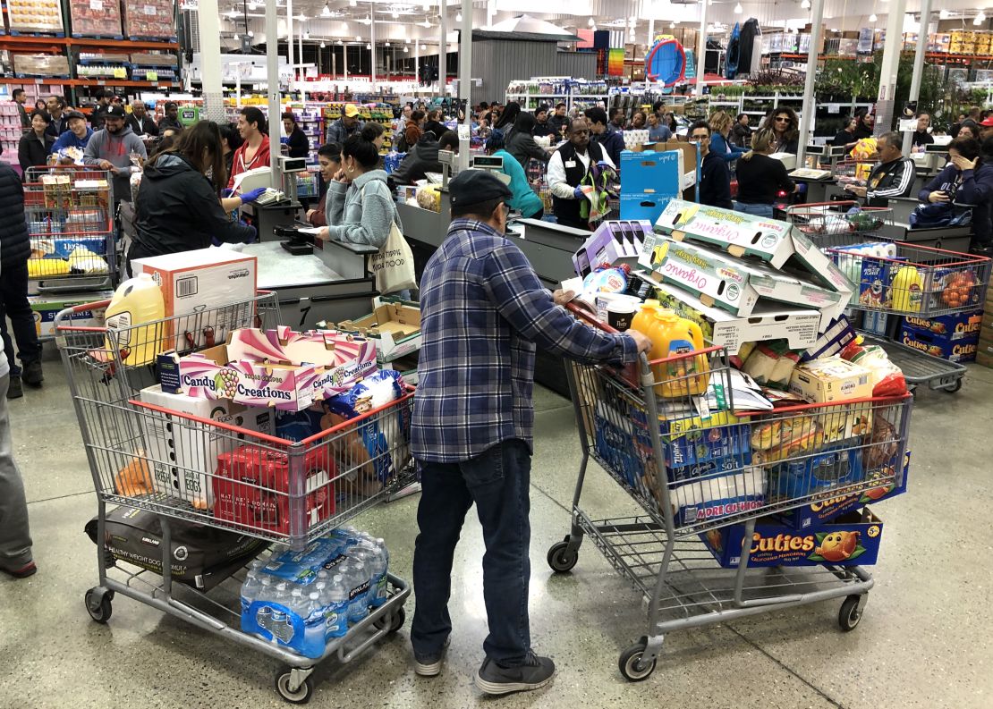 A Costco customer stands by his two shopping carts at a Costco store in Richmond, California, on Friday, March 13.