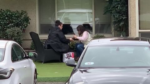 Sisters Bridgett Parkhill and Carmen Gray eat lunch outside their mother's window while their mother eats her meal inside the nursing home.