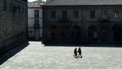 Two women walk in the empty Quintana Square in Santiago de Compostela on March 14, 2020 after regional authorities ordered all shops in the region be shuttered from today through March 26, save for those selling food, chemists and petrol stations, in order to slow the coronavirus spread. (Photo by MIGUEL RIOPA / AFP) (Photo by MIGUEL RIOPA/AFP via Getty Images)