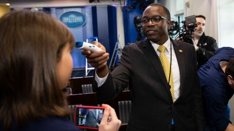 A member of the White House physician's office takes a media member's temperature in the White House briefing room on March 14. It was ahead of a news conference with President Donald Trump and Vice President Mike Pence.