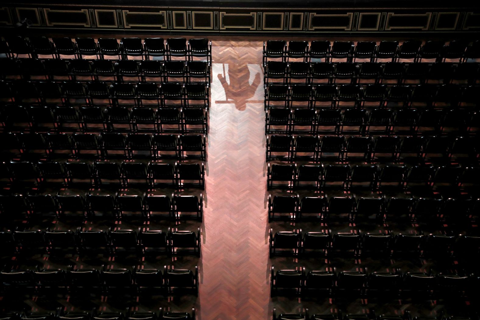 The reflection of conductor Mate Hamori is seen as he conducts the Danubia Orchestra without an audience at the Liszt Ferenc Academy of Music in Budapest, Hungary, on March 13.