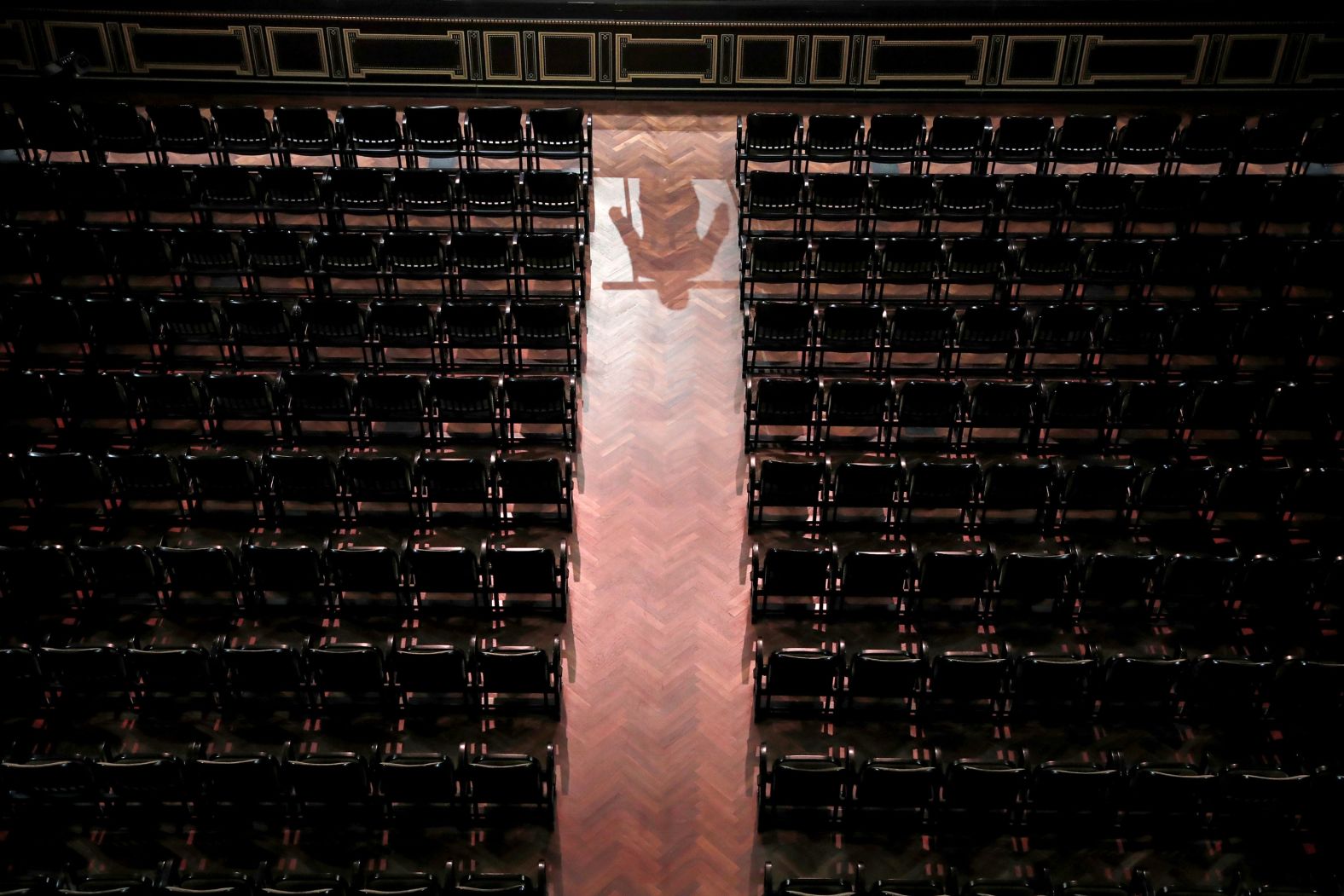 The reflection of conductor Mate Hamori is seen as he conducts the Danubia Orchestra without an audience at the Liszt Ferenc Academy of Music in Budapest, Hungary, on March 13.