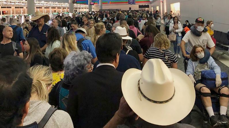 People wait in line to go through customs at Dallas/Fort Worth International Airport on March 14. Travelers returning from Europe say they were <a href="https://trans.hiragana.jp/ruby/https://www.cnn.com/travel/article/coronavirus-airport-screening-sunday/index.html" target="_blank">being made to wait for hours </a>at US airports, often in close quarters, as personnel screened them for the coronavirus.
