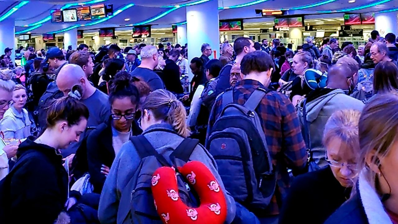 Travelers returning from Madrid wait in a coronavirus screening line at Chicago's O'Hare International Airport on Saturday.