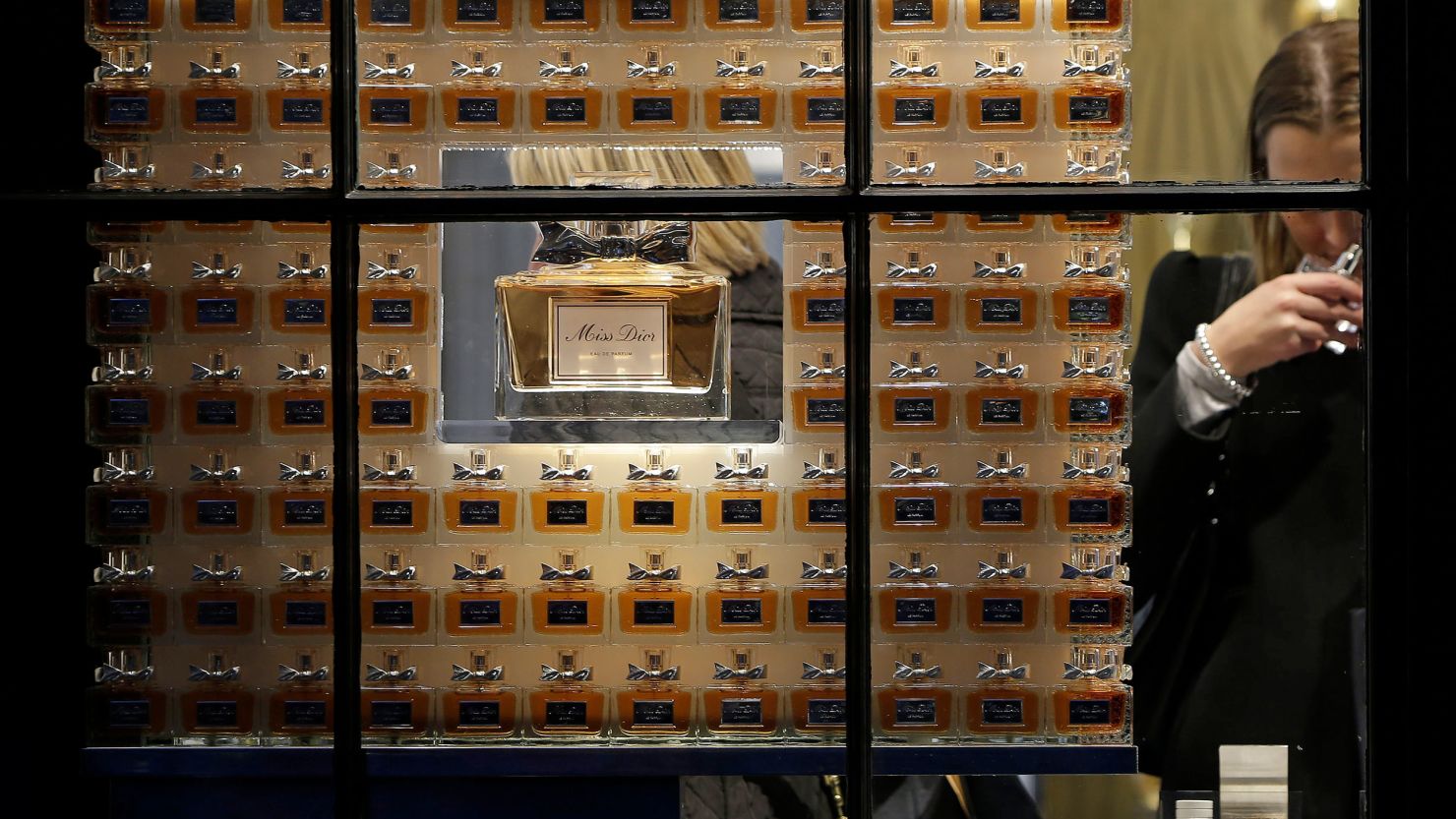 Customers sample Miss Dior perfumes inside a Dior store. 