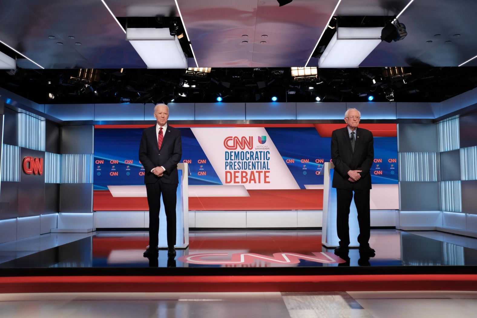 The two candidates stand farther apart than normal while posing for photos before the debate.