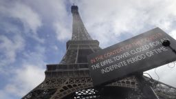 A picture taken on March 14, 2020 near the Eiffel tower in Paris shows a board informing of the monument's closure as a precaution against the coronavirus. - Paris' top tourists sites, including the Louvre and the Eiffel Tower, are closed because of the coronavirus, as France said it was banning all gatherings of more than 100 people. (Photo by Thomas SAMSON / AFP) (Photo by THOMAS SAMSON/AFP via Getty Images)