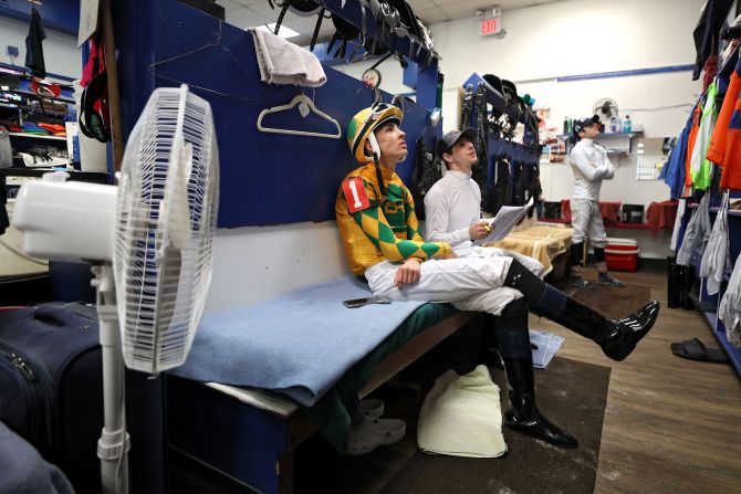 Jockey Charlie Marquez watches TV prior to racing at Maryland's Laurel Park on Sunday, March 15. Races continued on Sunday but there were no spectators.