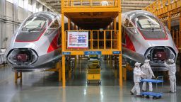 This photo taken on March 11, 2020 shows workers checking newly-made bullet trains at a factory in Qingdao in China's eastern Shandong province.