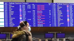 A passenger walks past an information board announcing flight cancellations at Arlanda international airport outside Stockholm, with the airport being unusually empty due to concerns over the spread of the novel coronavirus on March 16, 2020. (Photo by Fredrik SANDBERG / TT NEWS AGENCY / AFP) / Sweden OUT (Photo by FREDRIK SANDBERG/TT NEWS AGENCY/AFP via Getty Images)