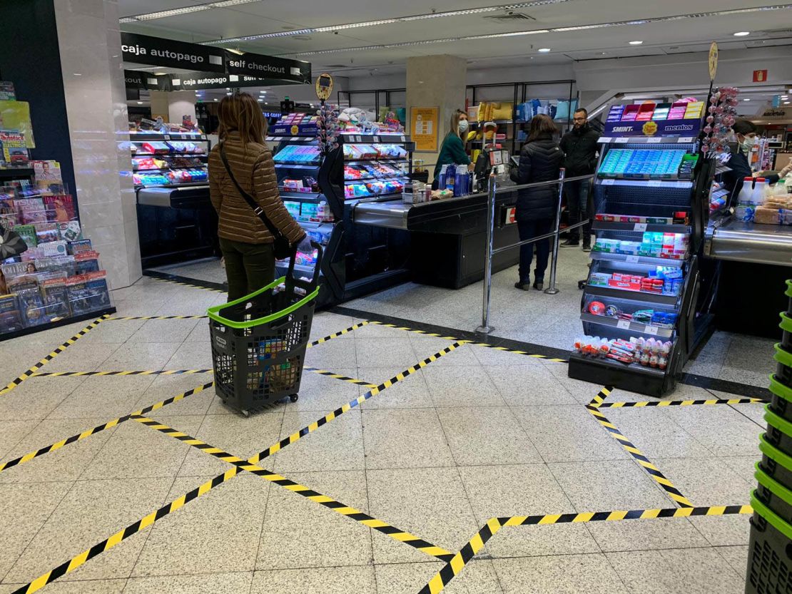 At a supermarket in central Madrid, lines taped on the ground indicate how far apart customers should stand.