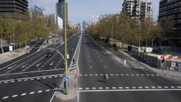 TOPSHOT - A woman crosses the usually busy La Castellana avenue in Madrid on March 15, 2020. - France and Spain are the latest European nations to severely curtail people's movements as countries across the Americas and Asia impose travel restrictions in a widening crisis over coronavirus, as the number of infections around the world passed 150,000, with nearly 6,000 deaths. (Photo by Oscar Del Pozo/AFP/Getty Images)