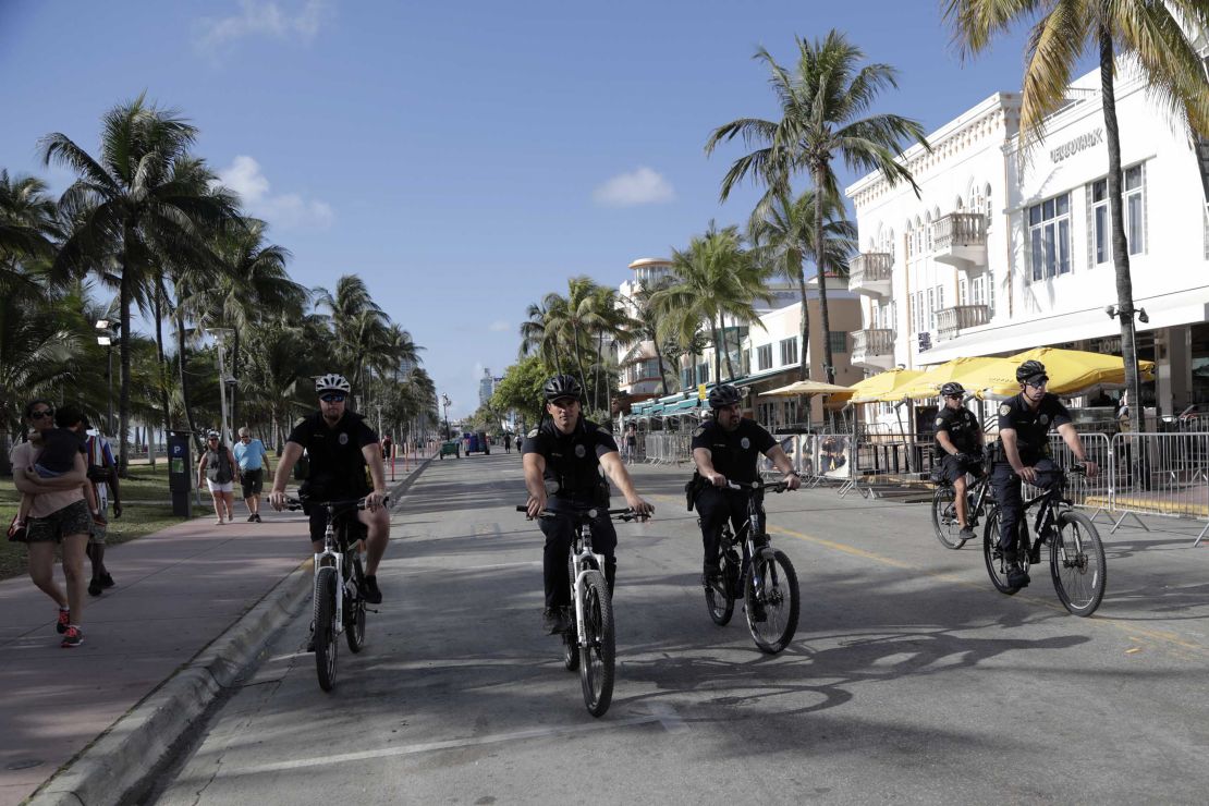 Miami Beach police officers patrol on Ocean Drive on Sunday.