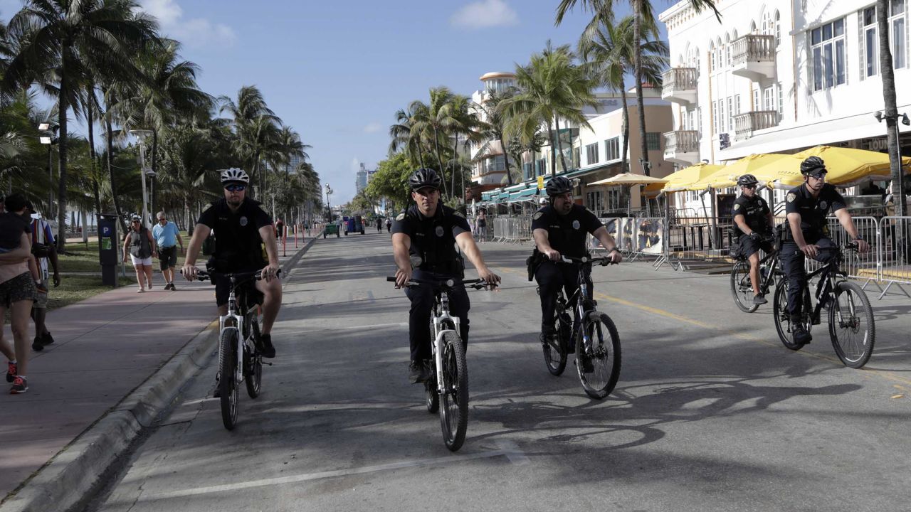 Miami Beach police officers patrol on Ocean Drive on Sunday.