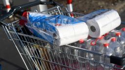 A picture taken on photo on March 16, 2020 shows a shopping cart with toilet paper and mineral water at a supermarket in Dortmund, where activities came to a halt due to the novel coronavirus. (Photo by Ina FASSBENDER / AFP) (Photo by INA FASSBENDER/AFP via Getty Images)