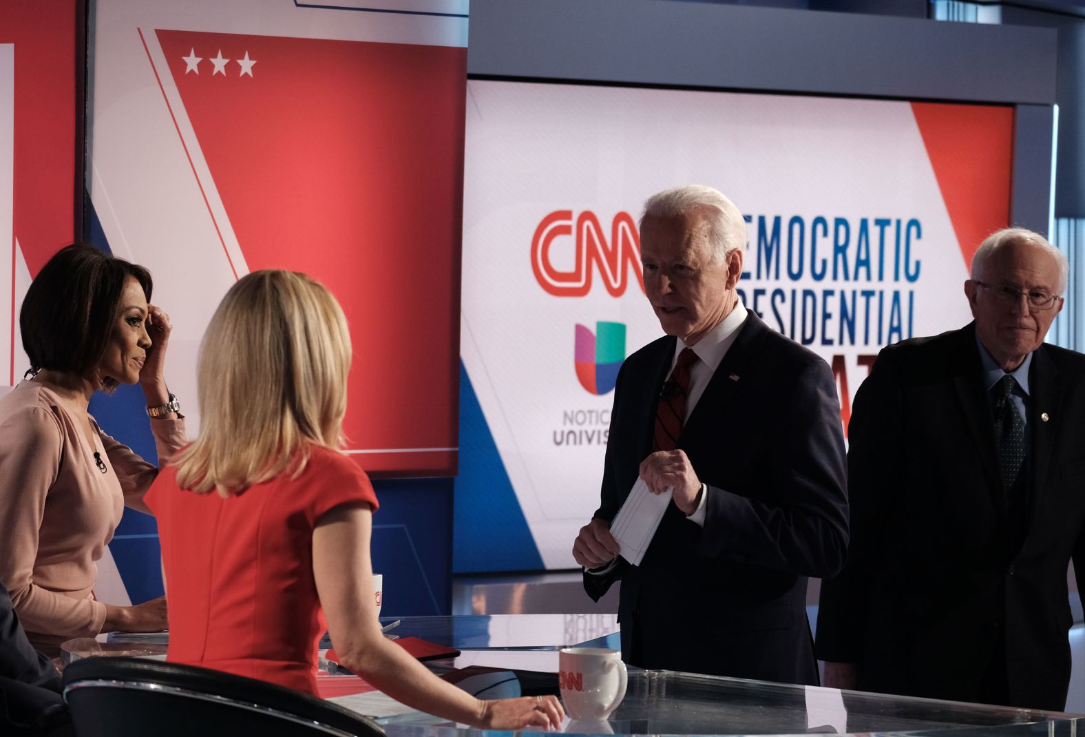 Sanders walks by as Biden talks to the moderators after the debate.