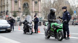 French police officers patrol and control citizens in Paris on March 17, 2020 while a strick lockdown comes into in effect to stop the spread of the COVID-19 in the country. - French President asked people to stay at home to avoid the spreading the Covid-19, saying only necessary trips would be allowed and violations would be punished. The country has already shut cafes, restaurants, schools and universities and urged people to limit their movements. (Photo by Thomas SAMSON / AFP) (Photo by THOMAS SAMSON/AFP via Getty Images)