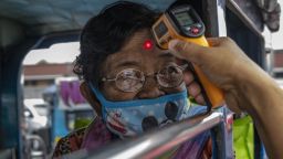 MARIKINA, PHILIPPINES - MARCH 16: An elderly woman riding a passenger jeepney has her temperature checked at a checkpoint as authorities begin implementing lockdown measures on March 16, 2020 in Marikina, Metro Manila, Philippines. The Philippine government expanded Monday its lockdown on capital Manila to the whole of Luzon, the largest and most populous island in the country, to prevent the spread of COVID-19. The Philippines' Department of Health has so far confirmed 142 cases of the new coronavirus in the country, with at least 12 recorded fatalities. (Photo by Ezra Acayan/Getty Images)